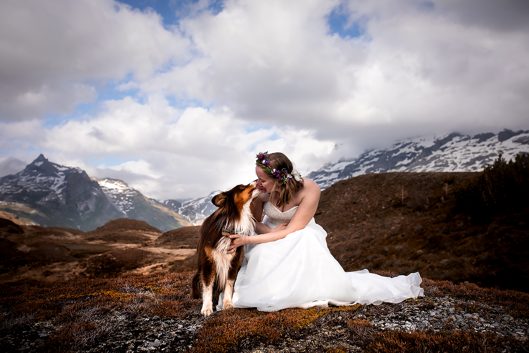 Eine Braut mit ihrem Hund auf der Melchsee Frutt im Kanton Obwalden. Der Hund gibt der Braut ein Küsschen.